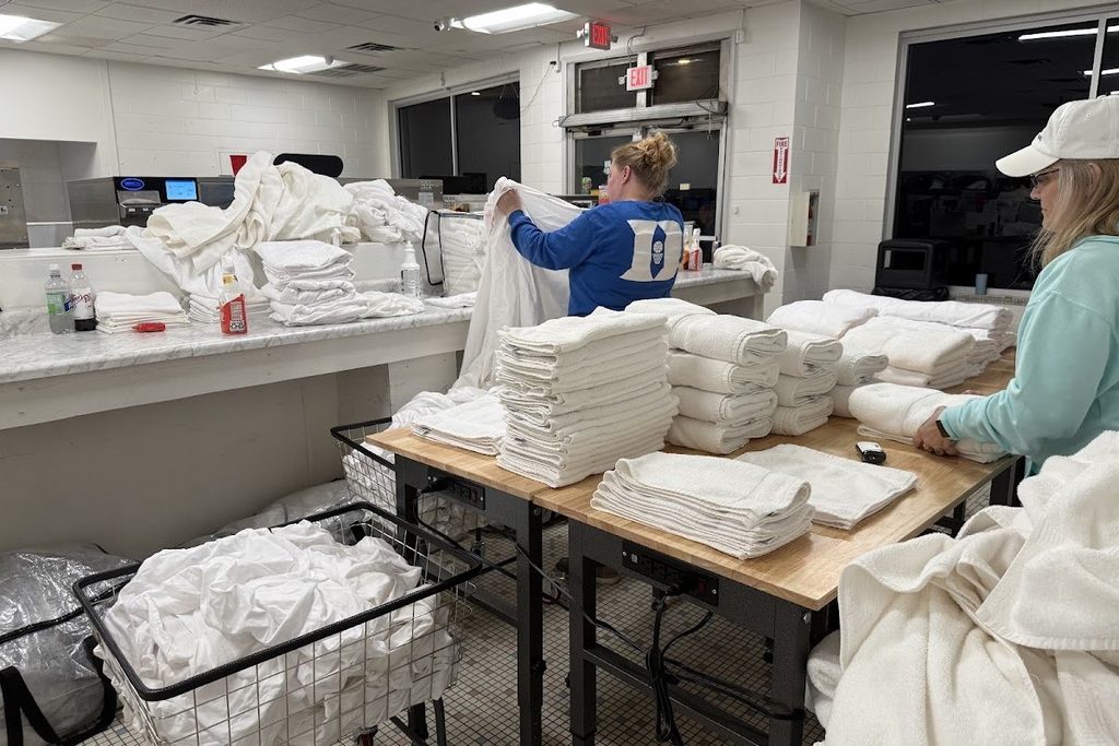 Highlander Laundromat team folding cabin rental linens in Nelsonville Ohio